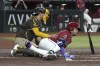 Arizona Diamondbacks' Ketel Marte, right, falls into San Diego Padres catcher Kyle Higashioka after getting hit with a pitch in the first inning during a baseball game, Saturday, Sept. 28, 2024, in Phoenix. (AP Photo/Rick Scuteri)