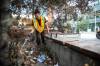Downtown Winnipeg BIZ Enviro Team member Jeremy Roulette cleans trash from behind the bench at Carlton and Graham on Sept. 4. (Mikaela MacKenzie / Free Press files)