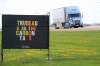 A semi-trailer passes by a sign opposing the federal carbon tax on Highway 10 outside Boissevain earlier this summer. (Tim Smith/The Brandon Sun)