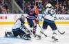Winnipeg Jets goalie Eric Comrie (1) makes the save as Dylan Coghlan (52) and Edmonton Oilers' Sam O'Reilly (72) battle in front during second period NHL preseason action in Edmonton, Sunday, Sept. 22, 2024. THE CANADIAN PRESS/Jason Franson