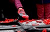 A person wearing a mitten embroidered with a poppy lays a poppy on the Tomb of the Unknown Soldier, after the National Remembrance Day Ceremony at the National War Memorial in Ottawa, on Saturday, Nov. 11, 2023. THE CANADIAN PRESS/Justin Tang