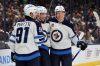 Winnipeg Jets forward Nikolaj Ehlers, center, celebrates his second goal against the Columbus Blue Jackets with teammate forward Cole Perfetti, left, and forward Vladislav Namestnikov during the first period of an NHL hockey game in Columbus, Ohio, Friday, Nov. 1, 2024. Ehlers scored three during the game and the Jets won 6-2. (AP Photo/Paul Vernon)