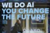 A woman is reflected in a window with a slogan about AI ahead of the World Economy Forum in Davos, Switzerland, Sunday, Jan. 19, 2025. (AP Photo/Markus Schreiber)
