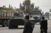 FILE - Syrian fighters watch Russian armoured vehicles driving past near the Hmeimim Air Base, a Syrian airbase currently operated by Russia, in the town of Hmeimim, southeast of Latakia, Syria, Monday Dec. 16, 2024.(AP Photo/Leo Correa, File)