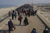 Displaced Palestinians walk on a road to return to their homes in the northern Gaza Strip, Tuesday, Jan. 28, 2025, after Israel's decision to allow thousands of them to go back for the first time since the early weeks of the 15-month war with Hamas. (AP Photo/Abdel Kareem Hana)