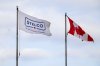 A Stelco flag flies beside a Canadian flag at the steel production facility in Hamilton, Ont., on Monday, February 10, 2025. THE CANADIAN PRESS/Nick Iwanyshyn
