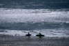 FILE - Two surfers walk with their boards on the beach of the Atlantic Ocean in Sines, Portugal, April 1, 2024. (AP Photo/Michael Probst, File)