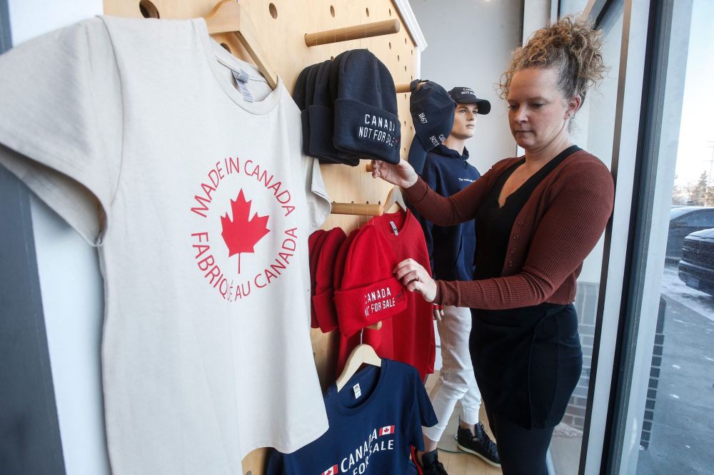 JOHN WOODS / FREE PRESS
Kara McDowell adjusts the display of Canadian products in her store, T-Shirt Connection on Taylor Ave., Wednesday.