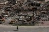 A worker walks in a devastated neighbourhood in west Jasper, Alta., on Monday, Aug. 19, 2024. Wildfire caused evacuations and widespread damage in the National Park and Jasper townsite. THE CANADIAN PRESS/Amber Bracken