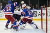FILE - Florida Panthers left wing Ryan Lomberg (94) collides with New York Rangers goaltender Igor Shesterkin (31) as New York Rangers defenseman Ryan Lindgren (55) helps defend during the third period of Game 1 of the NHL hockey Eastern Conference Stanley Cup playoff finals, May 22, 2024, in New York. Lomberg was called for goalie interference negating a goal scored by the Panthers on the play. (AP Photo/Julia Nikhinson, File)