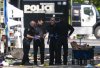 Members of the Vancouver Police forensics team examine a victim's phone while investigating the scene where a vehicle drove into crowd at a street festival Saturday evening in Vancouver, Sunday, April 27, 2025. THE CANADIAN PRESS/Rich Lam