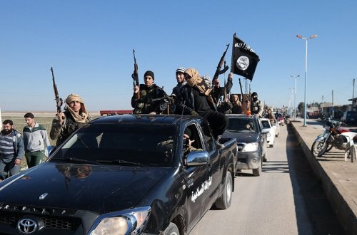 FILE - In this file photo released on May 4, 2015, by a militant website, which has been verified and is consistent with other AP reporting, Islamic State militants drive in a convoy through Tel Abyad, northeast Syria. (Militant website via AP, File)