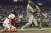 San Diego Padres' Jose Iglesias, right, hits a sacrifice fly next to San Francisco Giants catcher Patrick Bailey, left, that scored Jake Cronenworth during the tenth inning of a baseball game in San Francisco, Monday, June 2, 2025. (AP Photo/Jeff Chiu)