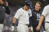 A trainer and manager Aaron Boone, left, check on Anthony Volpe after Volpe was hit by a pitch during the second inning of a baseball game against the Boston Red Sox, Friday, June 6, 2025, in New York. (AP Photo/Frank Franklin II)