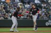 Washington Nationals' Robert Hassell III, right, celebrates his first career home run with third base coach Ricky Gutierrez during the eighth inning of a baseball game against the Seattle Mariners Wednesday, May 28, 2025, in Seattle. (AP Photo/Ryan Sun)