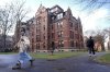 FILE - People walk between buildings, Dec. 17, 2024, on the campus of Harvard University in Cambridge, Mass. (AP Photo/Steven Senne, File)