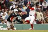 Baltimore Orioles catcher Adley Rutschman, left, cannot handle the throw as Boston Red Sox's Ceddanne Rafaela, right, scores during the eighth inning in the first baseball game of a doubleheader Friday, May 23, 2025, at Fenway Park in Boston. (AP Photo/Winslow Townson)