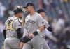 New York Yankees right fielder Aaron Judge, front, congratulates catcher J.C. Escarra, back left, and relief pitcher Luke Weaver after a baseball game against the Colorado Rockies, Sunday, May 25, 2025, in Denver. (AP Photo/David Zalubowski)