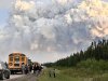 People stop along a highway as a large active wildfire fills the sky with smoke in the background in the La Ronge, Sask., area in an undated handout photo. THE CANADIAN PRESS/HO-Saskatchewan Public Safety Agency, *MANDATORY CREDIT*