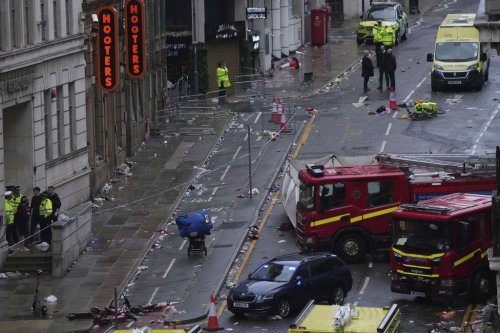 Fans leave as Police and emergency personnel deal with an incident after a car collided with pedestrians near the Liver Building during the Premier League winners parade in Liverpool, England, Monday, May 26, 2025.(AP Photo/Jon Super)