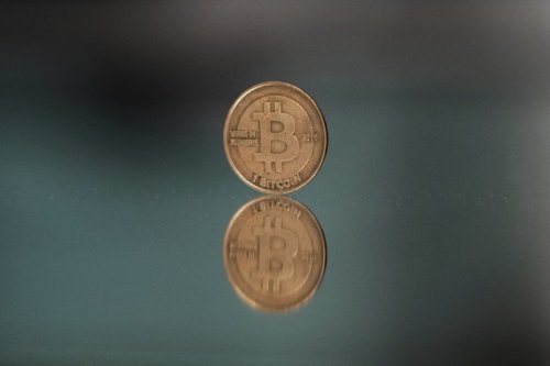 FILE - A bitcoin token is placed on a mirror for a photograph in Prague, Czech Republic, Sunday, May 11, 2025. (AP Photo/Petr David Josek, File)