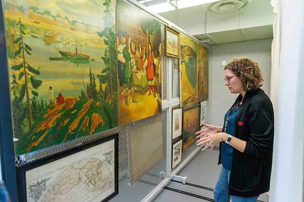 HBC MUSEUM COLLECTION / MANITOBA MUSEUM 
Amelia Fay, Curator of Anthropology and the HBC Museum Collection at the Manitoba Museum, shows paintings that would have been on display in stores.