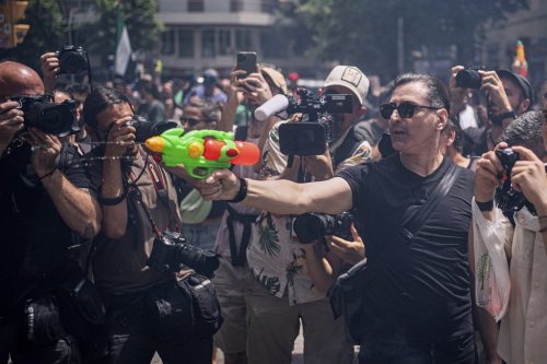 A protester holds a water gun during a protest against overtourism in Barcelona, Spain, Sunday, June 15, 2025. (AP Photo/Pau Venteo)