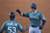Seattle Mariners' Mitch Garver, right, celebrates with first base coach Eric Young Jr. (53) after hitting a run-scoring single in the sixth inning of a baseball game against the Texas Rangers, Sunday, June 29, 2025, in Arlington, Texas. (AP Photo/Tony Gutierrez)
