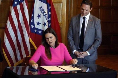 FILE - Arkansas Gov. Sarah Huckabee Sanders signs a bill requiring age verification before creating a new social media account as Sen. Tyler Dees, R-Siloam Springs, looks on during a signing ceremony, Wednesday, April 12, 2023, at the state Capitol in Little Rock, Ark. (Thomas Metthe/Arkansas Democrat-Gazette via AP, File)