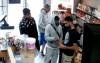 SUPPLIED
                                Security video shows a group of four men suspected of extortion interacting with a store employee, right, at Magnus Foods Wednesday.