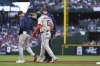 Houston Astros' Isaac Paredes (15) is walked back to the dugout with an apparent injury after running to first base on a single against the Seattle Mariners during the third inning of a baseball game Saturday, July 19, 2025, in Seattle. (AP Photo/Lindsey Wasson)