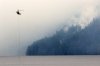 A helicopter refills a bucket of water at Cameron Lake off Highway 4 where the Wesley Ridge wildfire continues to burn out-of-control near Coombs, B.C., on Sunday, Aug. 3, 2025. THE CANADIAN PRESS/Chad Hipolito