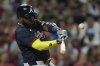 Atlanta Braves designated hitter Marcell Ozuna hits a sacrifice fly to score Matt Olson during the tenth inning of a baseball game against the Cincinnati Reds, Thursday, July 31, 2025, in Cincinnati. (AP Photo/Carolyn Kaster)
