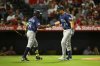 Seattle Mariners' Cal Raleigh, right, is greeted by Randy Arozarena, left, after hitting a home run during the sixth inning of a baseball game against the Los Angeles Angels, Saturday, July 26, 2025, in Anaheim, Calif. (AP Photo/William Liang)