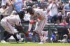 Minnesota Twins third base coach Tommy Watkins, left, congratulates Royce Lewis, right, who circles the bases after hitting a solo home run off Colorado Rockies relief pitcher Ryan Rolison in the fourth inning of a baseball game Sunday, July 20, 2025, in Denver. (AP Photo/David Zalubowski)