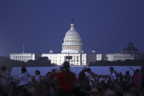 The U.S. Capitol building stands as people wait to watch fireworks near the Washington Monument during Fourth of July celebrations, in Washington, Friday, July 4, 2025. (AP Photo/Rahmat Gul)