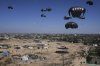 Palestinians rush to collect humanitarian aid airdropped into Zawaida in central Gaza Strip on Thursday, July 31, 2025. (AP Photo/Abdel Kareem Hana)