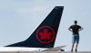 A potential strike looms as contract talks carry on between Air Canada and the union representing 10,000 of its flight attendants. A person watches as an Air Canada plane lands at Montreal-Pierre Elliott Trudeau International Airport in Montreal, Friday, Sept. 13, 2024.  THE CANADIAN PRESS/Christinne Muschi