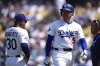 Los Angeles Dodgers' Freddie Freeman, left, walks off the field as manager Dave Roberts stands by after being hit by a pitch during the sixth inning of a baseball game against the Milwaukee Brewers, Sunday, July 20, 2025, in Los Angeles. (AP Photo/Mark J. Terrill)