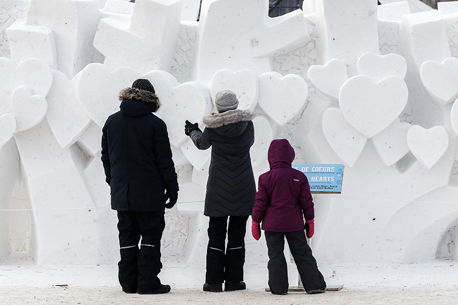 A family looks at the Forest Of Hearts snow sculpture at the Festival du Voyageur Sunday, February 16, 2025.