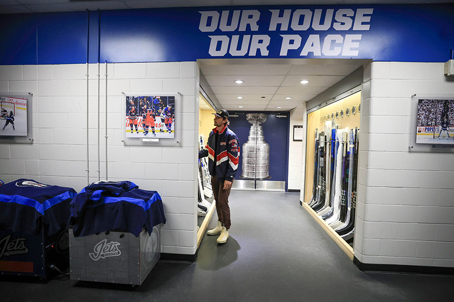 Wpg Jets, Connor Hellebuyck looks over a locker of hockey sticks before heading into a scrum in the Jets dressing room with the media. Players pack up for the season Tuesday.