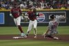 Arizona Diamondbacks second baseman Blaze Alexander (9) turns the double play while avoiding Boston Red Sox's Nathaniel Lowe (37) on a ball hit by Rob Refsnyder in the fourth inning of a baseball game, Sunday, Sept 7, 2025, in Phoenix. (AP Photo/Rick Scuteri)