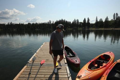 TIM SMITH / THE BRANDON SUN
                                28082025 Adam Vanstone readies kayaks for customers while working at The Clear Lake Marina in Riding Mountain National Park on Thursday. (Tim Smith/The Brandon Sun)