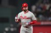 Philadelphia Phillies designated hitter Kyle Schwarber gestures while running the bases after hitting a solo home run off Texas Rangers pitcher Merrill Kelly during the first inning of a baseball game Friday, Aug. 8, 2025, in Arlington, Texas. (AP Photo/Julio Cortez)