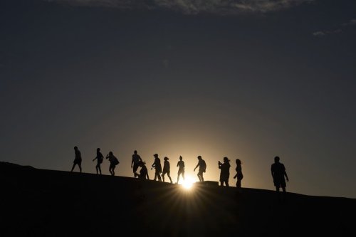 People walk up to an overlook at Zabriskie Point, Sunday, Aug. 3, 2025, in Death Valley National Park, Calif. (AP Photo/John Locher)