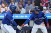 Toronto Blue Jays' Andrés Giménez, left, and teammate Ernie Clement celebrate at home plate after Clements scored on a sacrifice fly from Giménez against the Tampa Bay Rays during fourth inning MLB baseball action in Toronto on Sunday September 28, 2025. THE CANADIAN PRESS/Chris Young