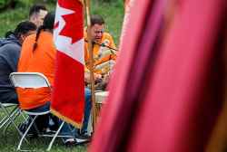 People attend a ceremony to unveil educational plaques at the memorial site at the Assiniboia Residential School Tuesday.