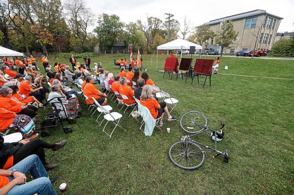 People attend a ceremony to unveil educational plaques at the memorial site at the Assiniboia Residential School Tuesday.