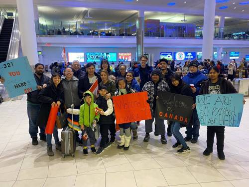 Staff at Naomi House and members of City Church greet the arrival of a refugee family from Afghanistan at the Winnipeg airport. (Supplied)