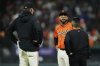 San Francisco Giants first baseman Dominic Smith, center, talks to manager Bob Melvin, left, and a trainer during the fourth inning of a baseball game against the Los Angeles Dodgers, Friday, Sept. 12, 2025, in San Francisco. (AP Photo/Godofredo A. Vásquez)
